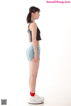 A woman leaning against a wall with her hand on the wall.