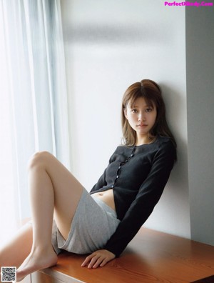 A woman laying on top of a bed next to a pillow.
