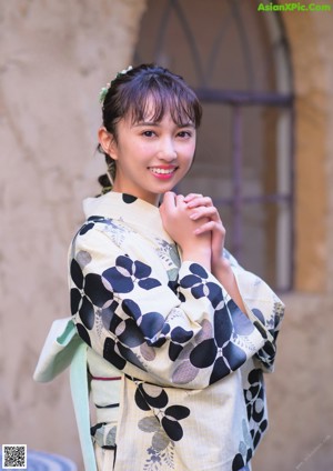 A woman in a kimono looking out of a window.