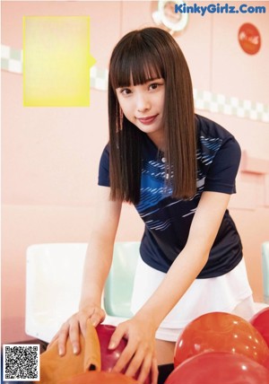 A woman holding a blue bowling ball in her hands.