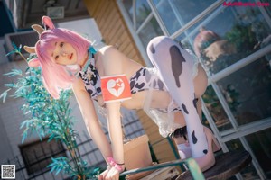 A woman with pink hair is posing on a wooden staircase.