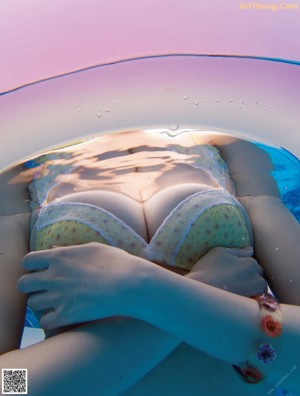 A woman sitting in a bathtub with her feet in the water.