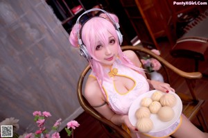 A woman in a pink dress holding a plate of food.