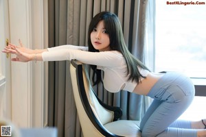 A woman sitting on a couch with her legs crossed.