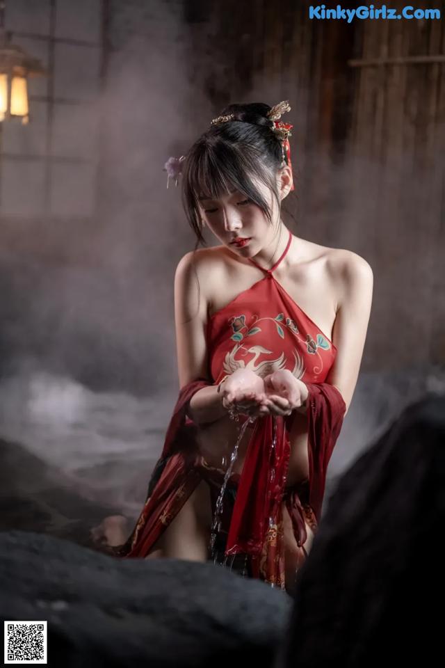 A woman in a red dress standing in a room.