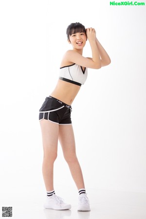 A woman in a black and white sports bra top and shorts.