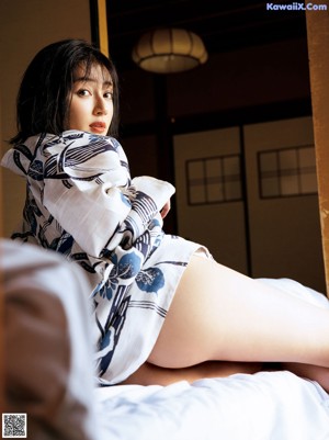 A naked woman laying in bed with her eyes closed.