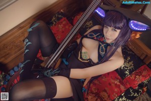 A woman in a black and blue outfit holding a musical instrument.