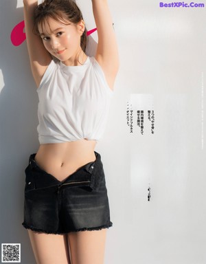 A woman laying on a bed wearing a sweater and shorts.