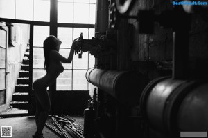 A naked woman sitting on a toilet in a bathroom.