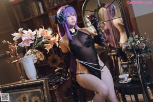 A woman in a black lingerie sitting on a chair.