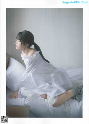 A woman in a white dress and fur coat posing for a magazine.