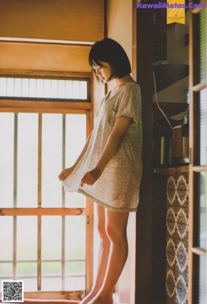 A woman in a school uniform crouching on the floor.