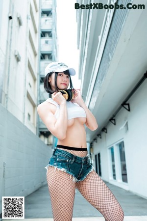 A woman in fishnet stockings and a white hat is posing for a magazine cover.