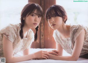 Two young women standing next to each other in a room.