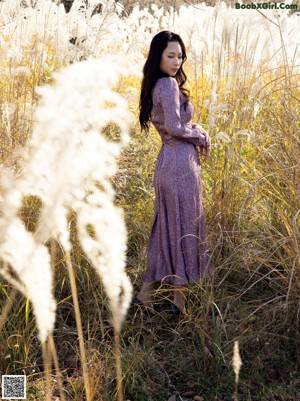 A woman holding a bunch of dry grass in her hands.