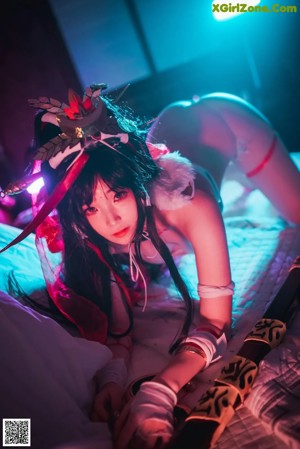 A woman in a white and red lingerie laying on a bed.