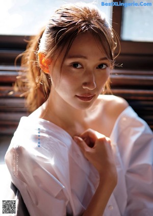 A woman with long brown hair smiles at the camera.