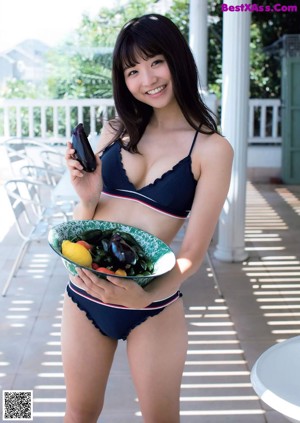 A woman in a bikini is posing on the beach.