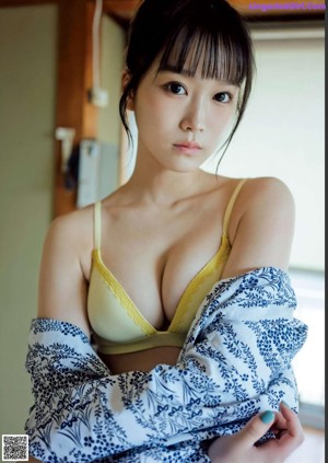 A naked woman sitting on a wooden bench holding a fan.