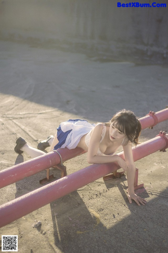A woman laying on top of a pink pipe.