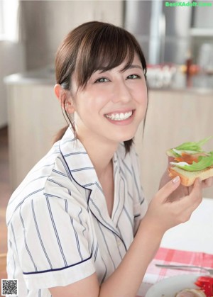 A woman in pajamas preparing food in a kitchen.