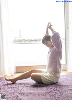 A woman in a blue top and yellow skirt posing for a picture.