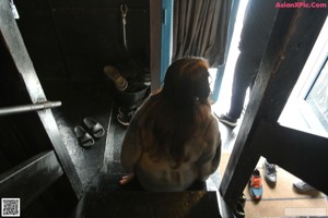 A woman standing in a bathroom next to a sink.