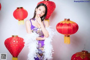 A woman in a purple and gold dress laying on a bed.