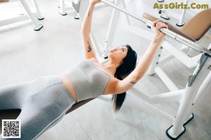A woman sitting on a stationary bike in a gym.