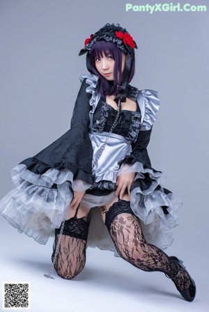 A woman in a maid outfit is posing for a picture.