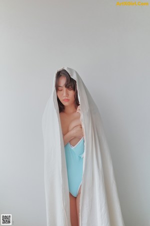 A woman in a blue and white bikini standing next to a wooden shelf.