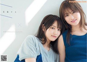 Two young women standing next to each other in a room.