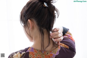 A woman in a kimono looking out a window.